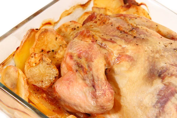 Запеченная курица с картошкой в стеклянной тарелке крупным планом — стоковое фото