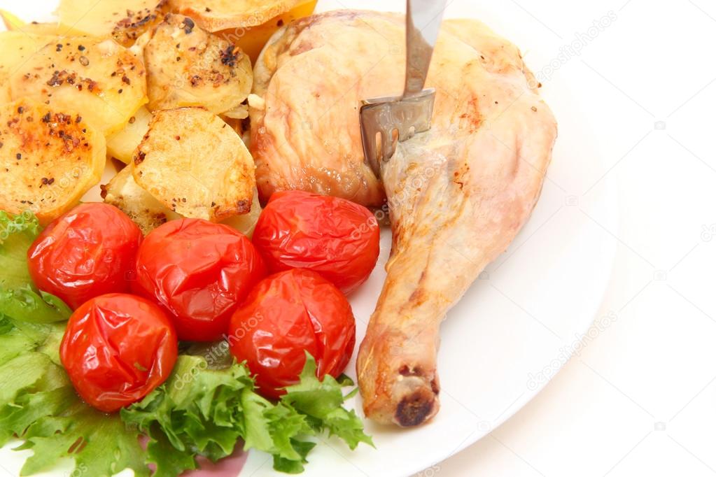fried chicken leg with potatoes and marinated tomatoes