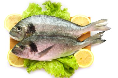 Doğrama Kurulu limon ve sebzeler üzerinde taze dorado