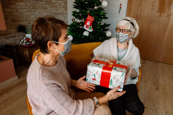 Ein Paar Älterer Freundinnen Mit Gesichtsmaske Die Ein Weihnachtsgeschenk Thanksgiving — Stockfoto