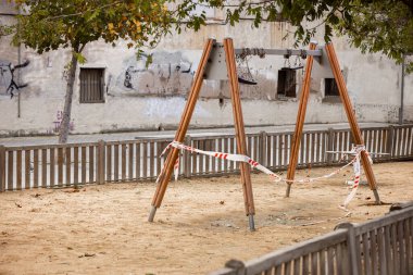 Covid-19 yüzünden terk edilmiş bir çocuk parkı. Kullanılmamak için yuvarlanan bebek salıncakları. Koronavirüs salgınının sonuçları: karantina, hapsedilme, sosyal hayat yok, kısıtlamalar.