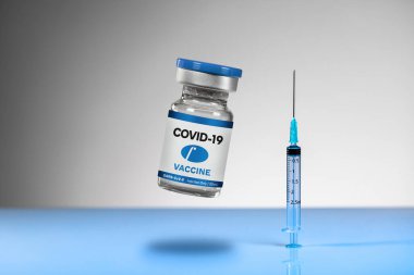 Üzerinde COVID-19 yazan cam ampul mavi yansıtıcı yüzey üzerinde mavi şırıngalı mavi bir VACCINE. Kas içi enjeksiyonlar. Olası tedavi, Coronavirüs salgını için çözüm..