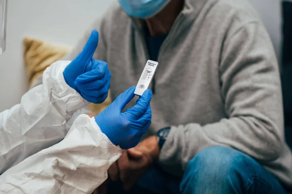 Närbild Läkare Händer Med Skyddshandskar Och Ppe Kostym Visar Testanordning — Stockfoto