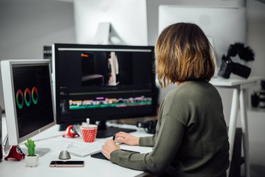 Modern ofiste çalışırken dijital grafik tableti kullanan grafik tasarımcı kadın. Modern çalışma alanında oturan profesyonel bayan rötuş ustası..