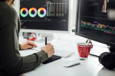 Ofisteki masadaki kadın grafik tasarımcısının iki görüntüsü, kurgu fotoğrafları ve bir kalem tabletiyle video görüntüleri. Yaratıcı ofis stüdyosunda serbest işçi..