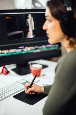 İş yerindeki kadın tasarımcı kurgu videosunun yakın çekimi. Modern iş kadını video tasarım bölümünde Yaratıcı Ofis 'te kalem tabletle çalışıyor. Serbest çalışanların ayrıntıları.