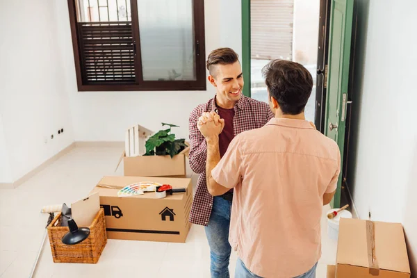 Smilende Ung Mann Holder Kjærestens Hånd Den Nye Leiligheten Nettopp – stockfoto