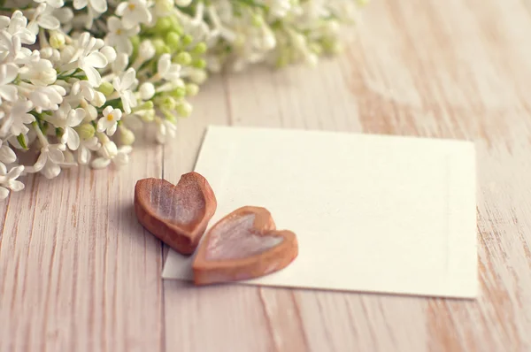 Deux cœurs sur la carte blanche vide pour une inscription et un bouquet d'un lilas blanc — Photo
