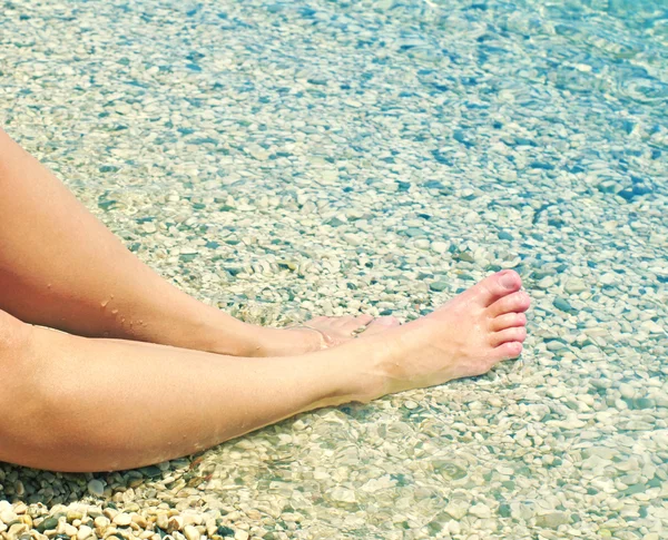 Kobiece stopy na plaży w słoneczny letni dzień nad morzem. — Zdjęcie stockowe