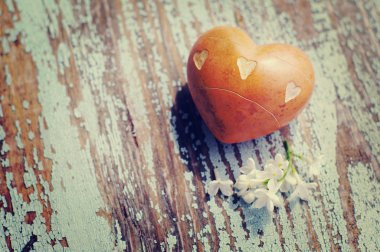 Eski bir ahşap zemin üzerine taşlarla kalp.