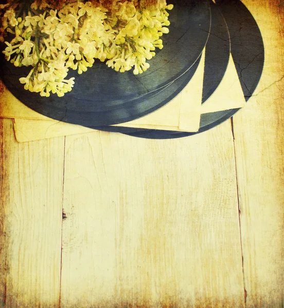 Antiguo disco de vinilo con un ramo de una lila blanca sobre fondo grunge vintage . — Foto de Stock