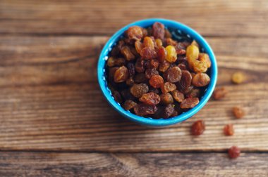 Ahşap masa üzerinde mavi bir küçük Platosu kuru üzüm