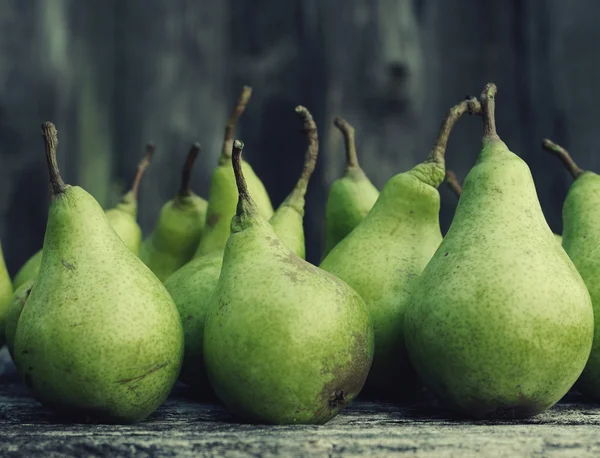 Pere verdi fresche contro una vecchia superficie di legno materico . — Foto Stock