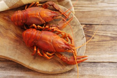 Ahşap arka plan üzerinde ahşap bir gemide haşlanmış crawfishes