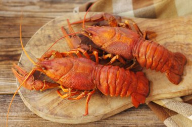 Ahşap arka plan üzerinde ahşap bir gemide haşlanmış crawfishes