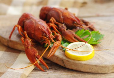 Ahşap arka plan üzerinde ahşap bir gemide haşlanmış crawfishes