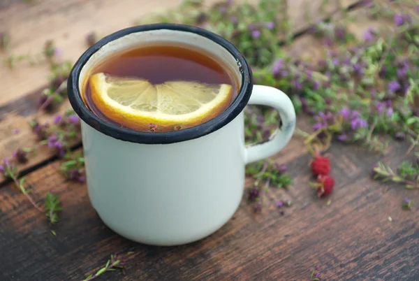 Чай в железной кружке, лимон, лекарственные травы — стоковое фото