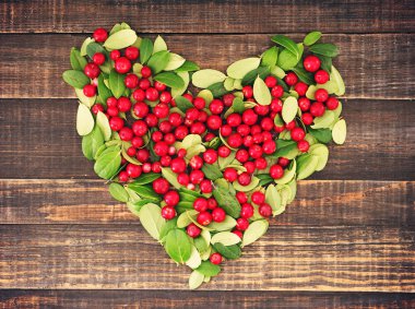 Sulu kırmızı çilek ve yeşil yaprakları Fuska yürekten