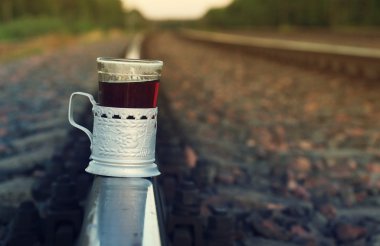 Çay bir eski alüminyum arka plan demiryolu üzerinde bardak altlığı.