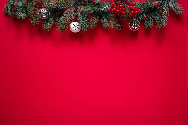モミの枝 鐘や赤い装飾ベリーとクリスマスの赤い背景 テキストのためのスペース トップビュー — ストック写真