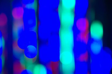 Bokeh mavi arka planı. Parlak renkli çemberler ve hareket halindeki çizgiler. Odaklanamayan soyut renkli ışıklar 