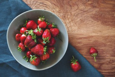 Taze sulu çilekler yeşil bir tabakta ahşap bir masada yakın plan, kopyalama alanı, üst görünüm
