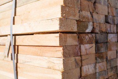 Tahta yığını, yakın çekim, yumuşak odaklanma. Tahtanın sonundaki yüzey. Yığılmış kereste, kereste, ahşap işçiliği