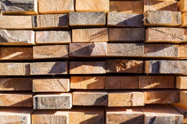 Tahta odunların arka planı, yakın plan. Tahtanın sonundaki yüzey. Yığılmış kereste, kereste, ahşap işçiliği