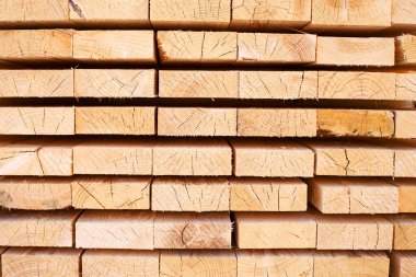 Tahta odunların arka planı, yakın plan. Tahtanın sonundaki yüzey. Yığılmış kereste, kereste, ahşap işçiliği