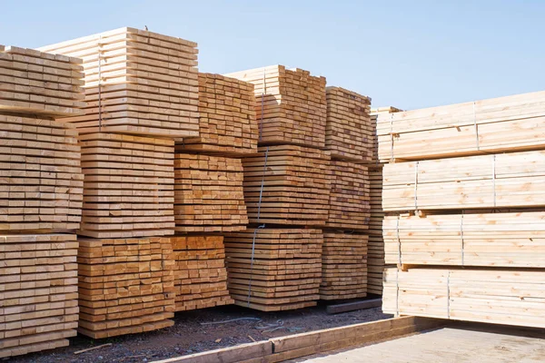 Gökyüzüne karşı istiflenmiş tahta yığınları. Kereste deposu, ahşap kurutma. İnşaat için kereste.