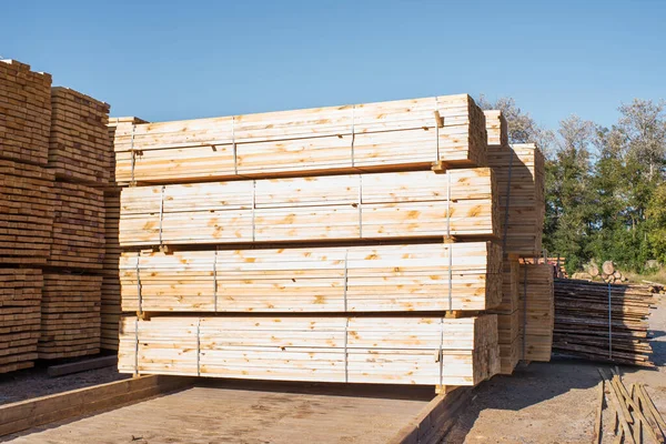 Gökyüzüne karşı istiflenmiş tahta yığınları. Kereste deposu, ahşap kurutma. İnşaat için kereste.