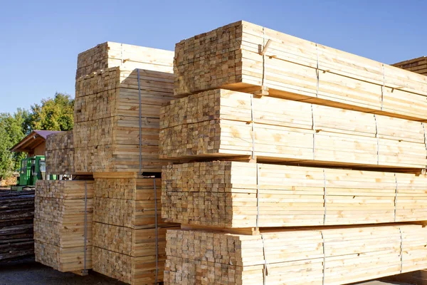 Gökyüzüne karşı istiflenmiş tahta yığınları. Kereste deposu, ahşap kurutma. İnşaat için kereste.