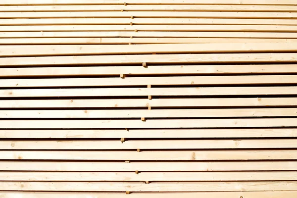 Tahta odunların arka planı, yakın plan. Yığınla ahşap tahta. Kereste deposu, ahşap kurutma, inşaat malzemeleri..