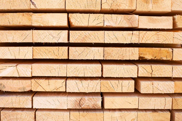 Tahta odunların arka planı, yakın plan. Tahtanın sonundaki yüzey. Yığılmış kereste, kereste, ahşap işçiliği