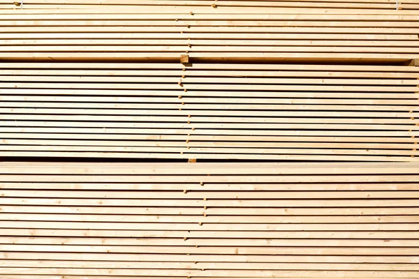 Tahta odunların arka planı, yakın plan. Yığınla ahşap tahta. Kereste deposu, ahşap kurutma, inşaat malzemeleri..