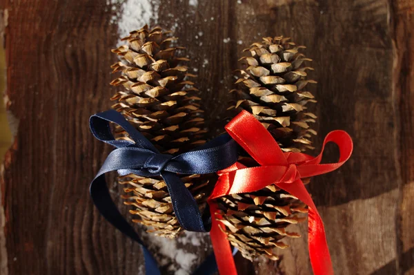 Dos conos de abeto festivos sobre un fondo de madera marrón —  Fotos de Stock