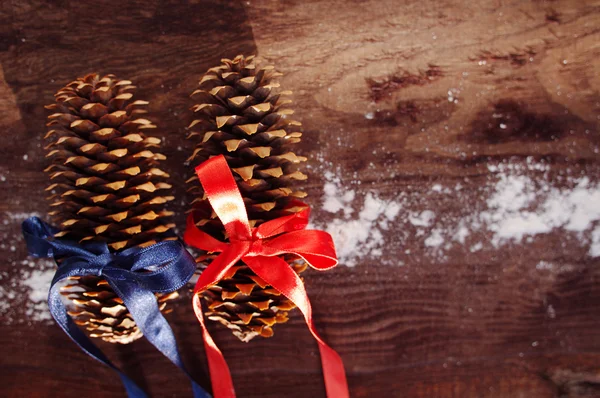 Two festive fir cones on a brown wooden background — Stock Photo, Image