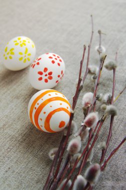 Bir söğüt dallarında bahar bir kumaş keten yüzeyle parlak çizim ile üç Paskalya yumurtaları