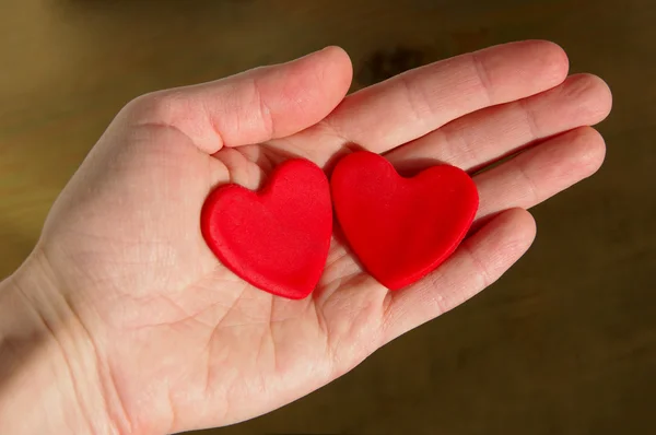 Two red hearts on a female hand — Stock Photo, Image