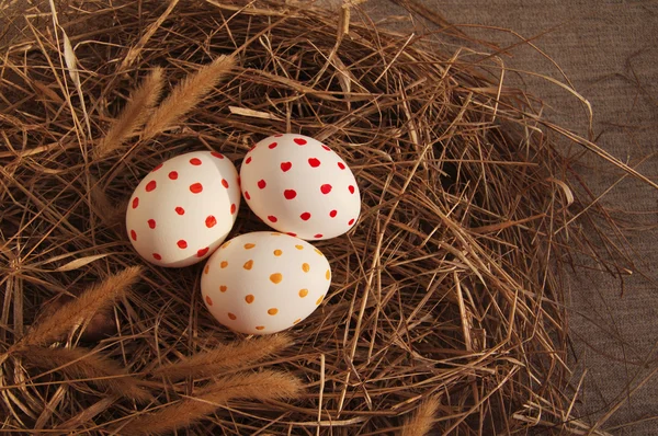 Три пасхальных яйца с ярким рисунком в гнезде из сухой травы — стоковое фото