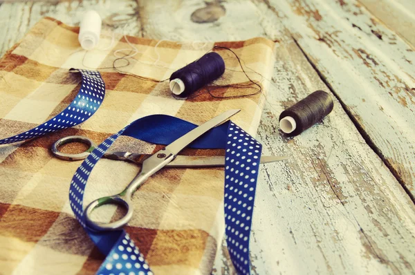 Tijeras, hilos, tela y cinta azul —  Fotos de Stock