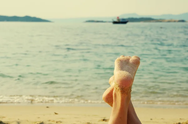 Kobiece stopy na plaży z morza — Zdjęcie stockowe