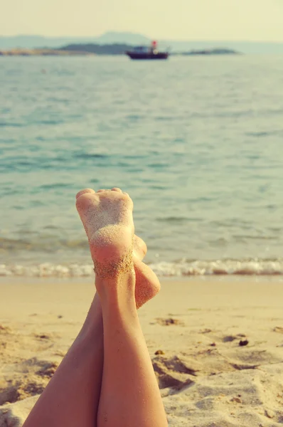 Kobiece stopy na plaży z morza — Zdjęcie stockowe