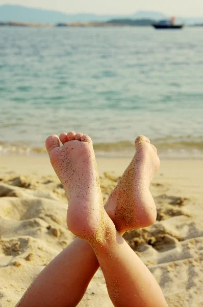 De voeten kind op een zee strand tegen de zee Stockfoto