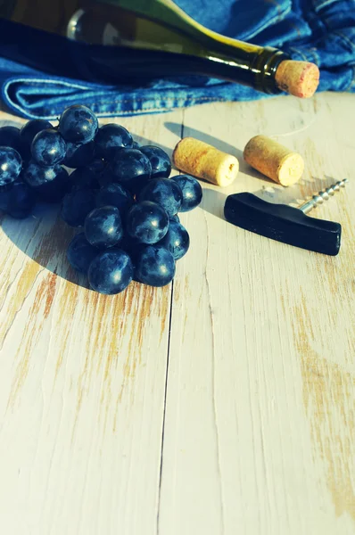 Flasche Rotwein, Trauben und Wein Staus auf einer Holzoberfläche — Stockfoto