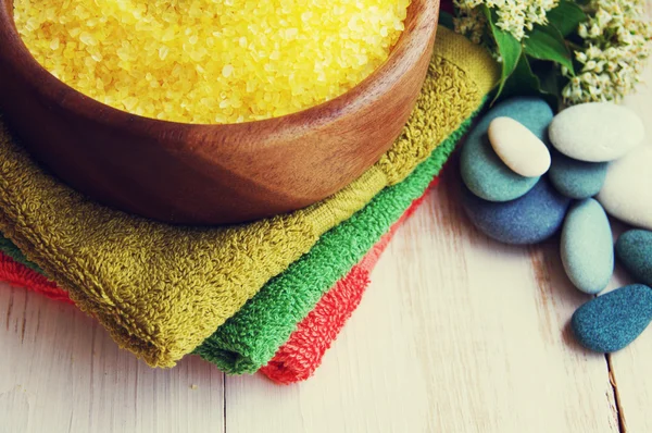 Aromatic salt for Spa therapies in a wooden bowl, with a towel and sea stones. Alternative medicine. Care of a body. — Stock Photo, Image