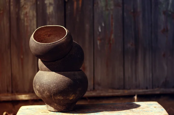 Old cast iron pot on a textural wooden surface. Old ware for the furnace — Stock Photo, Image