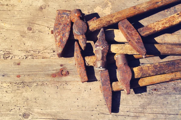 Martillos oxidados viejos sobre una superficie de madera textural. Herramientas antiguas — Foto de Stock