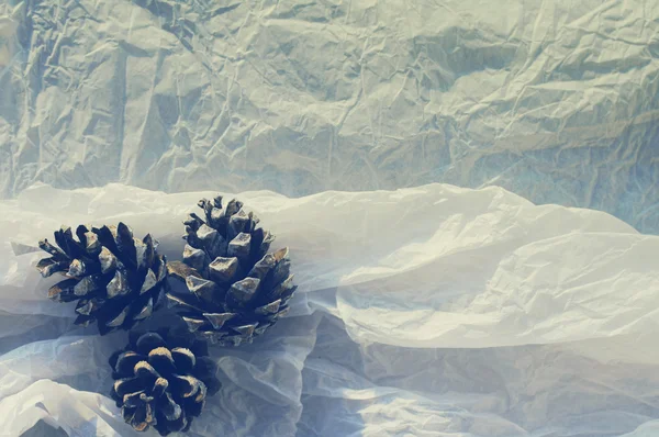 Сосновые шишки - Рождественский орнамент на текстурной белой мятой бумаге. Предыстория рождественских каникул. Декоративная открытка с рождественскими шишками . — стоковое фото