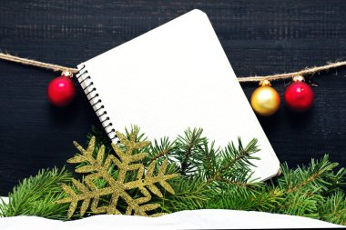 Noel kartı boş bir defter ve köknar ağacı dalları ile.